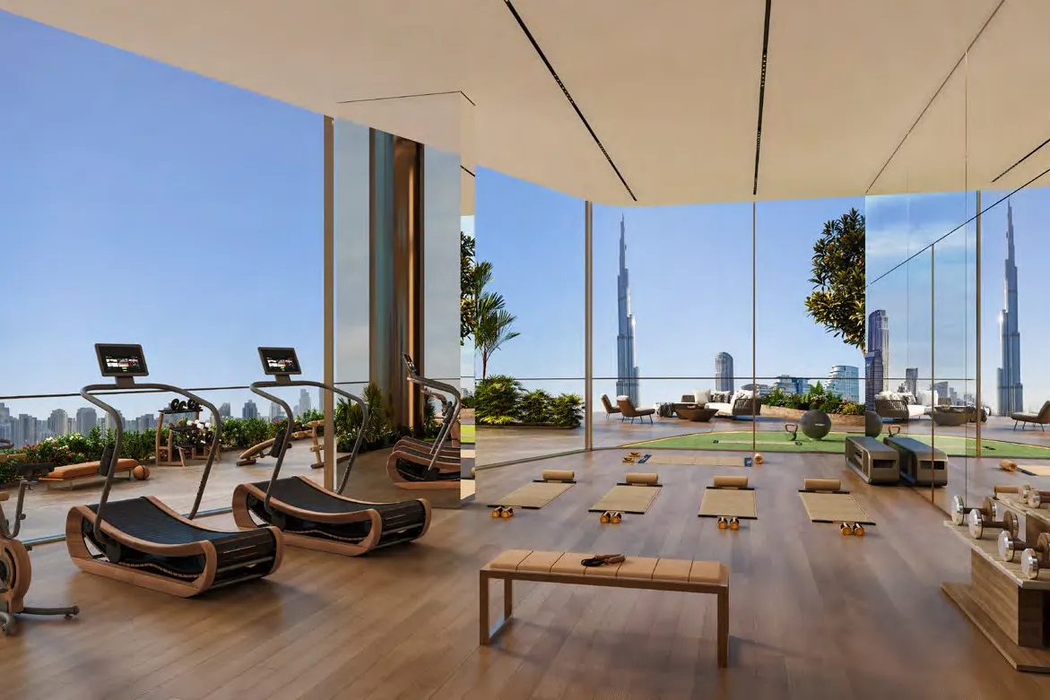 Glass-walled gym with treadmills and yoga mats overlooking the skyline